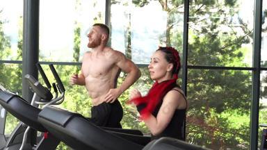 健身房跑步机运行教练男人。女人培训慢跑健身锻炼焦点男人。